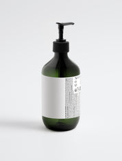 Grüne Kunststoffflasche mit schwarzem Pumpverschluss und weißem Etikett mit kleingedrucktem Text;