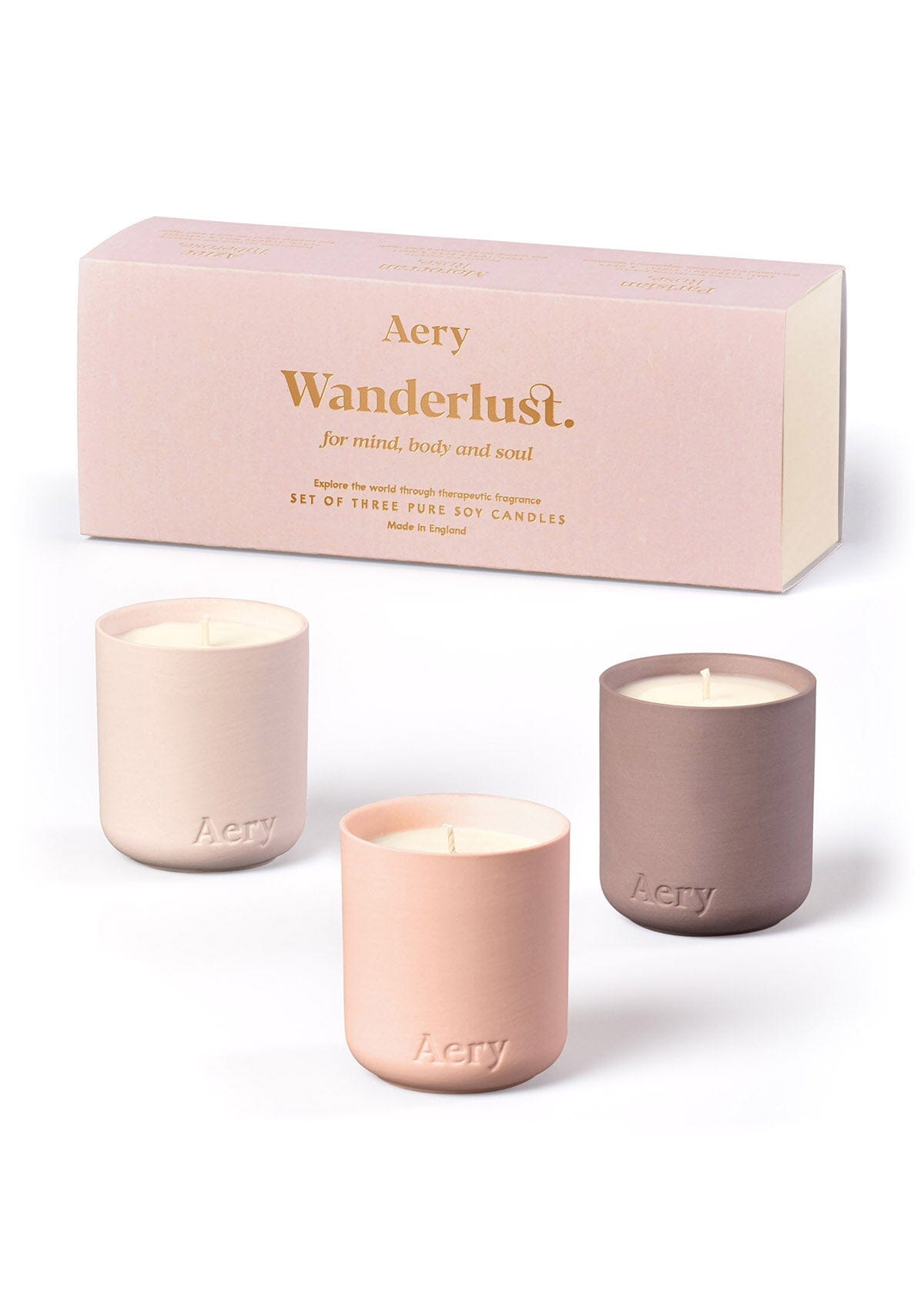 Geschenkset mit drei Aery Wanderlust Duftkerzen in pastellfarbenen Behältern aus Keramik vor rosa Verpackung;