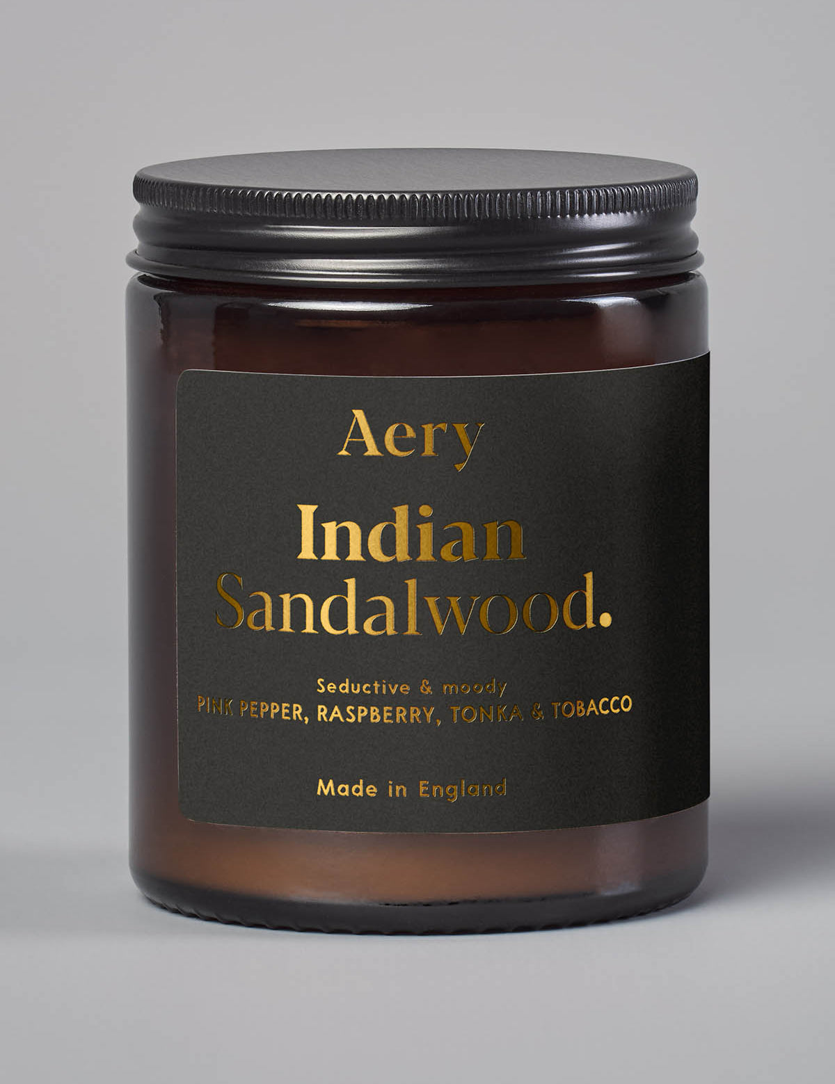 Braune Duftkerze im Glas mit schwarzem Deckel, Marke Aery, Duft 'Indian Sandalwood' mit Noten von Pfeffer, Himbeere, Tonka und Tabak;