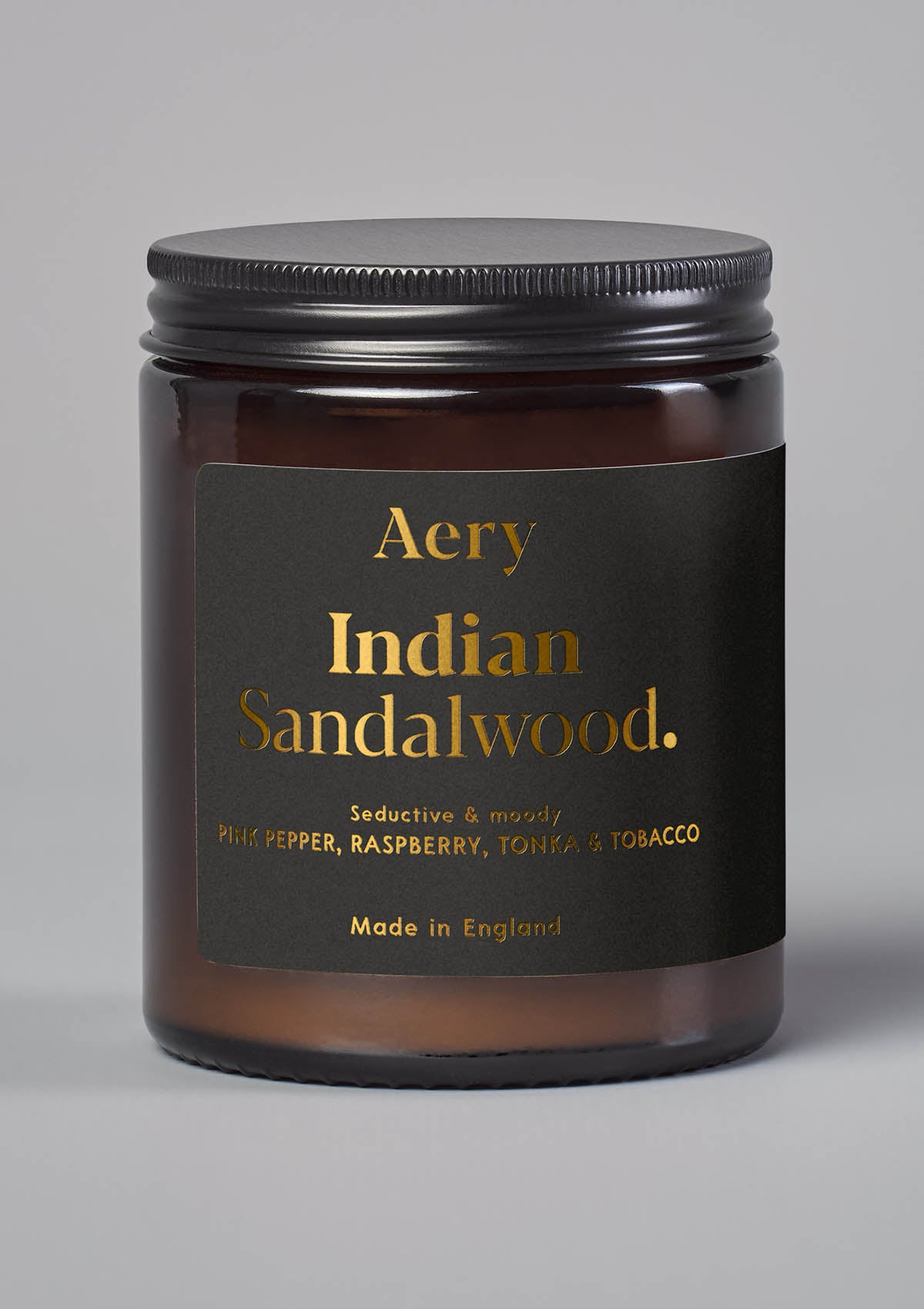 Braune Duftkerze im Glas mit schwarzem Deckel, Marke Aery, Duft 'Indian Sandalwood' mit Noten von Pfeffer, Himbeere, Tonka und Tabak;
