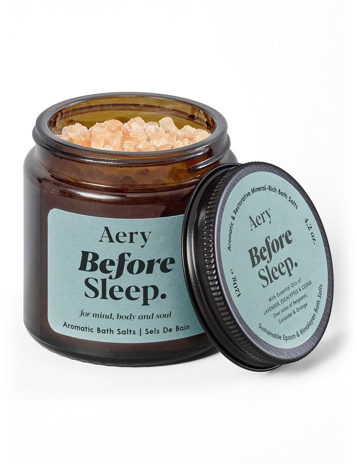 Braunes Glasgefäß mit aromatischen Badesalzen 'Aery Before Sleep' und geöffnetem Deckel mit Produktinformationen;