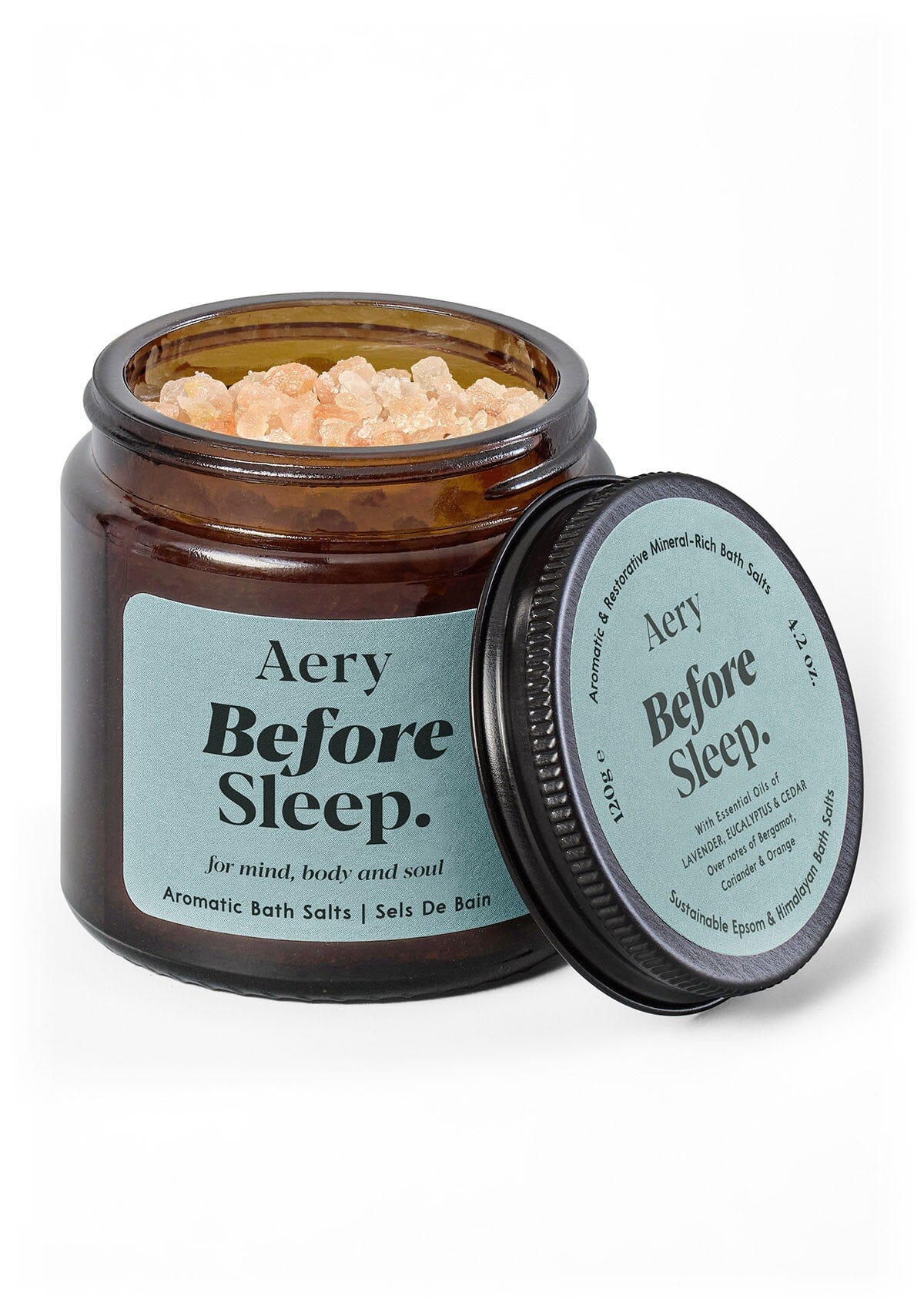 Braunes Glasgefäß mit aromatischen Badesalzen 'Aery Before Sleep' und geöffnetem Deckel mit Produktinformationen;