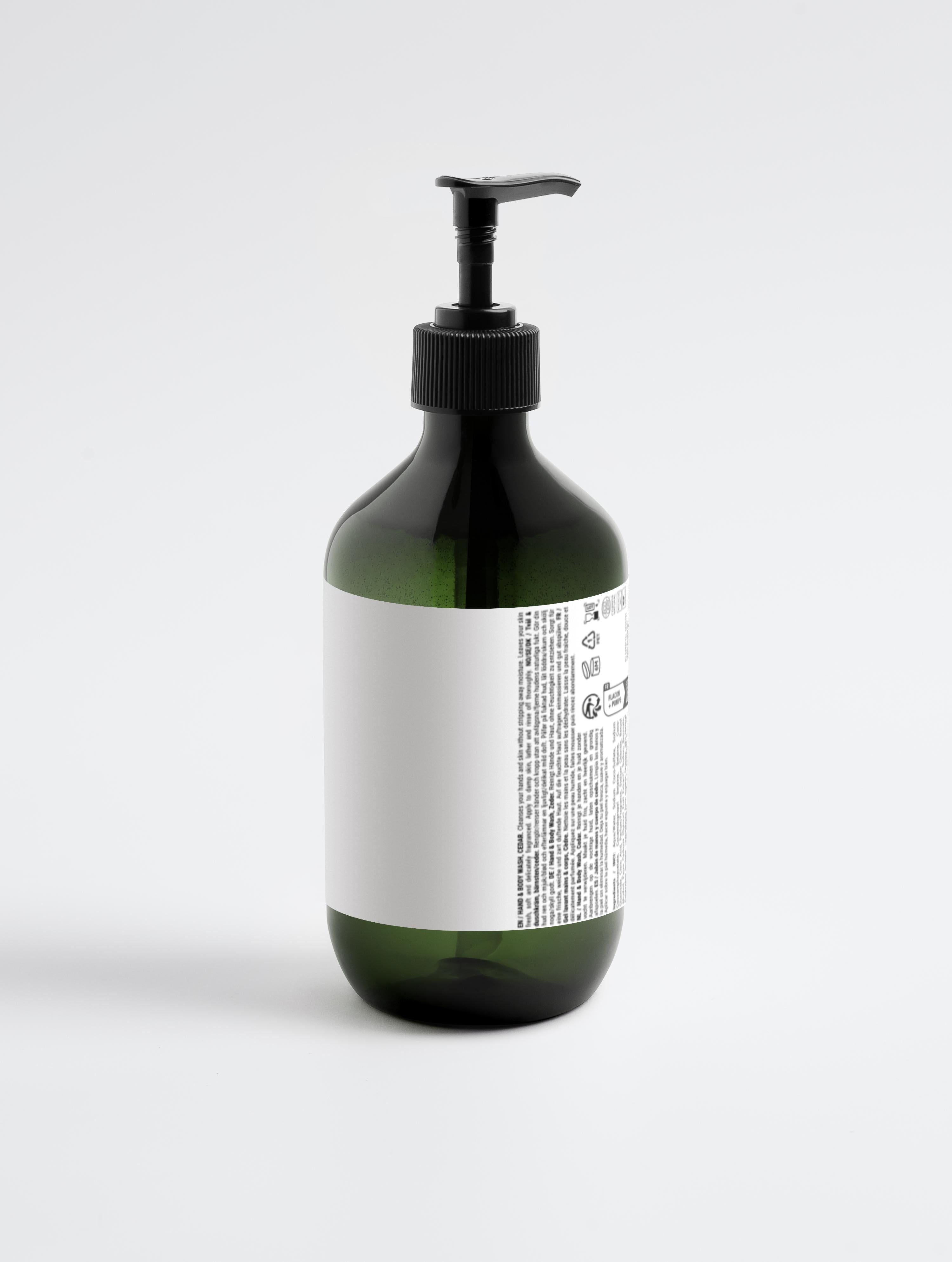 Grüne Flasche mit schwarzem Pumpverschluss und weißem Etikett mit kleingedrucktem Text;