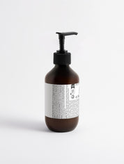 Braune Kunststoffflasche mit schwarzem Pumpspender und weißem Etikett mit kleingedrucktem Text;
