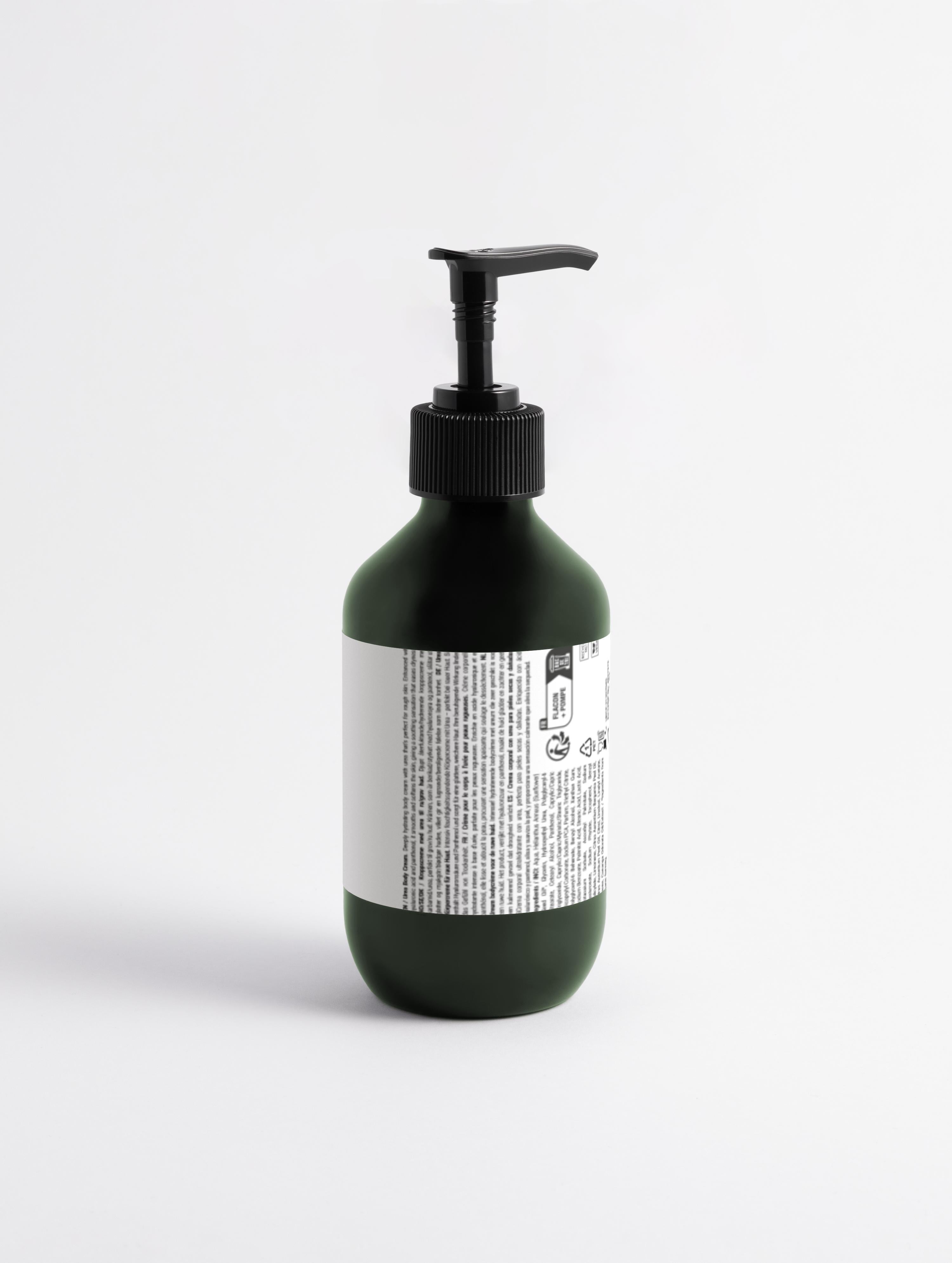Grüne Flasche mit schwarzem Pumpspender und weißem Etikett mit kleingedrucktem Text;