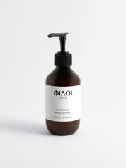 Braune Flasche mit schwarzem Pumpspender, Etikett mit Marke 'ΦΙΛΟΙ [filoi]' und Text 'SILK SKIN Body Serum 270 ml / 9.13 fl oz';
